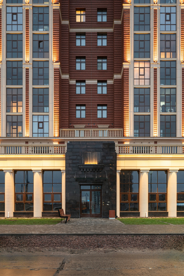 A fragment of the facade on the Dybenko Street. Portal of the entrannce to the commercial premises, the evening light. Renaissance housing complex Copyright: Photograph  Dmitry Tsyrenshchikov /provided by Liphart Architects