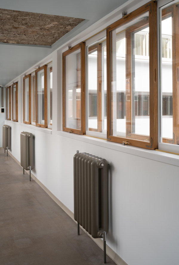 The interior of the corridor. The system of pull-out windows and the cast-iron radiators were restored. Restoration and adaptaion of the the cultural heritage site “Narkomfin Building” (2017-2020) Copyright: Photograph  Yuri Palmin / provided by Ginzburg Architects