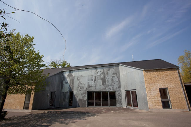 Перфорация на фасаде музыкальной школы в городе Nørresundby в Дании создает рисунок, изображающий поющих, играющих и танцующих детей. Проект разработан архитекторами Kærsgaard  Andersen A/S. 32 листа горячего цинкования (RMIG), сталь толщиной 2 мм, общая площадь 6х10 метров. Фотография Rmig.
