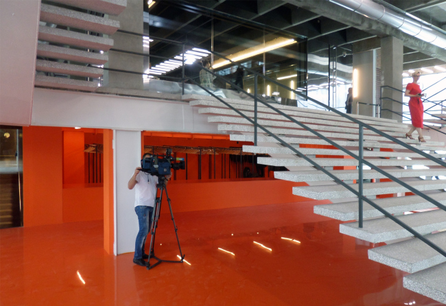 The bright orange cloakroom is one of the few interventions of today's architects into the modernist interior. Photograph  Ilia Mukosey