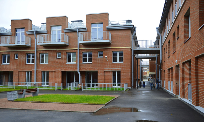 "Amazon" residential complex. Inner courtyard. To the left: stanzas and little garden belonging to the large apartment. On the right: suspension bridges to the "wall" house. Construction, 2015  Studio 44