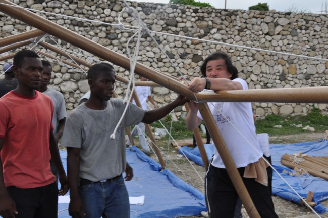 Shigeru Ban with volunteers constructing Paper Emergency Shelter in Haiti. Photo by Alex Martinez