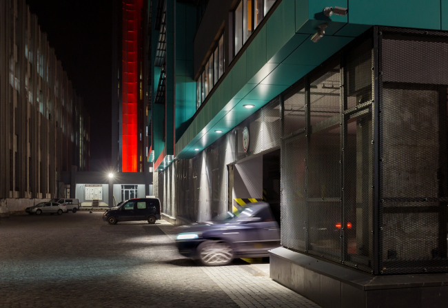 The facade that faces the yard and the slab of the soviet building of the Academy of Sciences (on the left). On this side, the podium hosts a parking garage; the glazing gives way to metallic bars. "Optima-Plaza" office complex  Archimatika