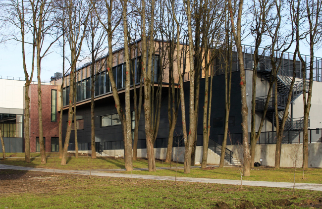 Yard with a lime tree avenue turned towards the Oka. Behind the trees one can see the northwest wall of the main hall. Innovation and Culture Center in Kaluga.  Photograph � Julia Tarabarina, Archi.ru
