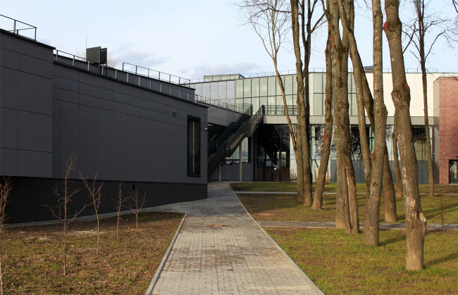 Yard with a lime tree avenue turned towards the Oka. On the left: educational work shops. On the right: the foyer. Innovation and Culture Center in Kaluga.  Photograph  Julia Tarabarina, Archi.ru