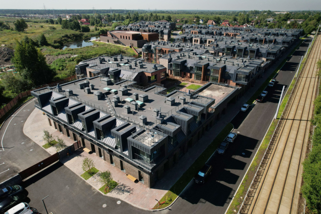 In this photo taken at the southern position of the sun, the three-dimensional prongs of the mansards cast a jagged shadow to the right, while the planning “comb” goes to the left. They seem to mirror each other. Veren Village housing complex