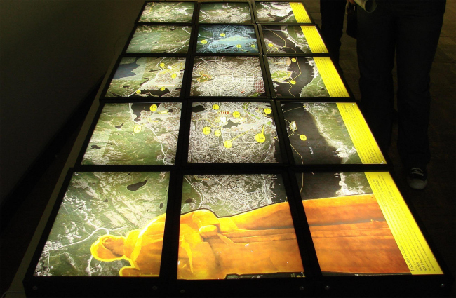 Проект Мурманск CMYK демонстрируется в темноте светящимися слайдами (на этой выставке наши преимущественно светятся, а иностранцы серьезно висят себе по стенам в виде планшетов). Идеи похожи на Пермь: уменьшение города, но дополнены забавынми мелочами: светящимися ставнями для пятиэтажек, например. Рядом, такими же слайдами, демонстрируется проект «Изумрудное кольцо планеты», посвященный модернизации городов за полярным кругом. С Мурманском их объединяет оптимистическая песня мультяшного трубадура про «солнце взойдет»; для полярного круга солнце актуально. Проект Мурманск CMYK демонстрируется в темноте светящимися слайдами (на этой выставке наши преимущественно светятся, а иностранцы серьезно висят себе по стенам в виде планшетов). Идеи похожи на Пермь: уменьшение города, но дополнены забавынми мелочами: светящимися ставнями для пятиэтажек, например. Рядом, такими же слайдами, демонстрируется проект «Изумрудное кольцо планеты», посвященный модернизации городов за полярным кругом. С Мурманском их объединяет оптимистическая песня мультяшного трубадура про «солнце взойдет»; для полярного круга солнце актуально.